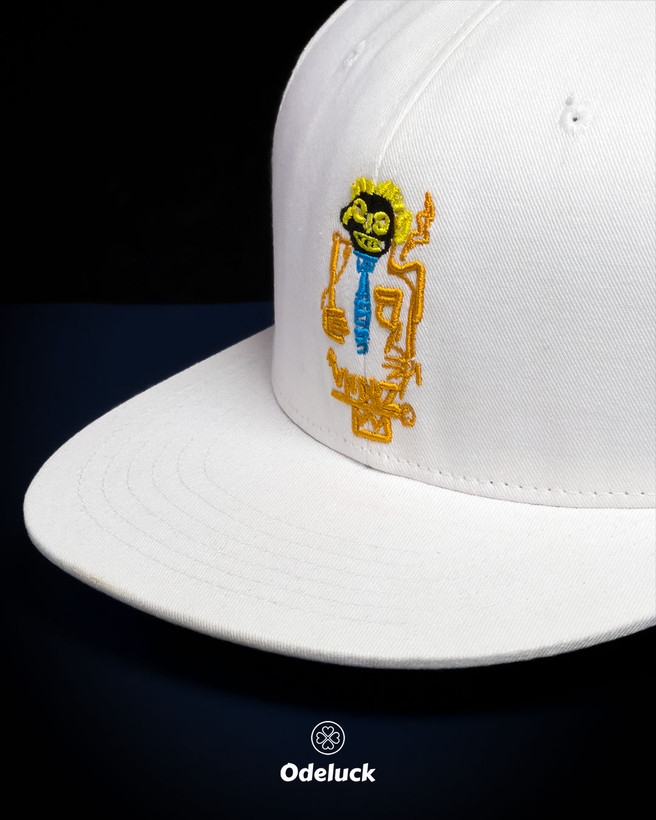 نمای نزدیک گلدوزی برجسته طرح VNDRZ روی کلاه کپ کتان سفید
