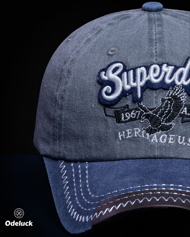نمای نزدیک گلدوزی برجسته طرح SUPERDRY HERITAGE U.S. روی کلاه سنگشور آبی